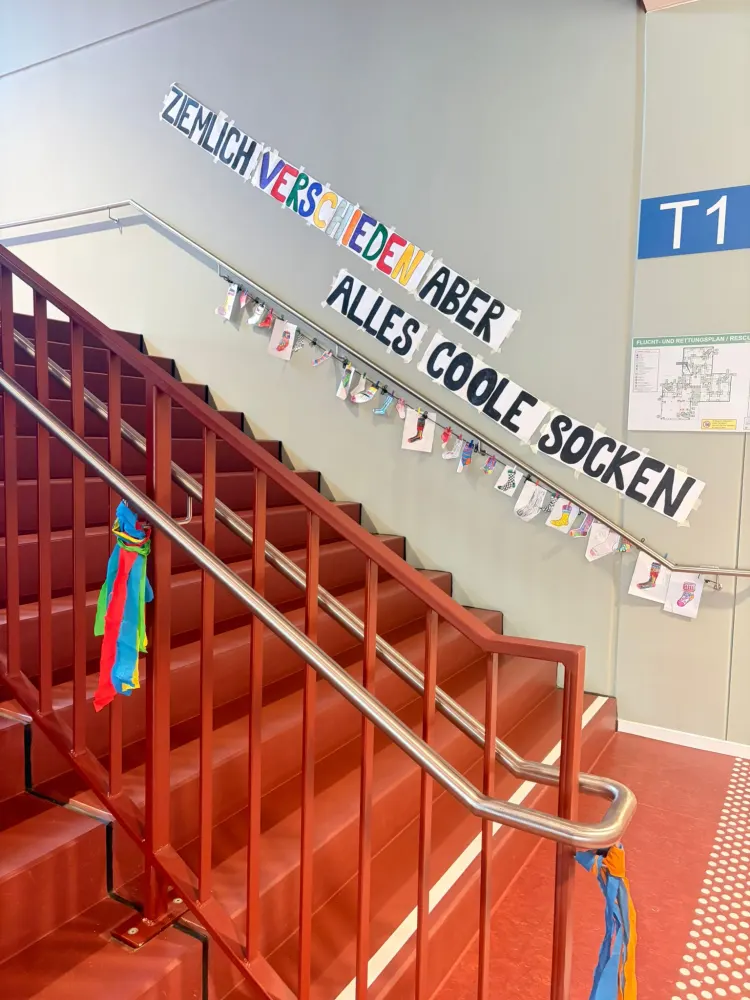 Treppenhaus mit dem Schriftzug Ziemlich verschieden aber alles coole Socken