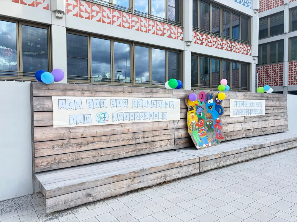 Eine geschmückte Holzwand mit dem Schriftzug Ich bin ein Schulkind der 37. Grundschule